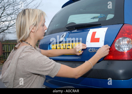 Ragazza L fissaggio piastra alla sua automobile Foto Stock