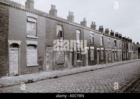 Le difficoltà economiche - una bottiglia di latte al di fuori del solo casa occupata in una strada a Bolton in Inghilterra in Gran Bretagna nel Regno Unito Regno Unito. La povertà Foto Stock