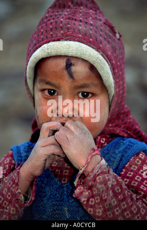 Una ragazza in Korzuk 4572 m. una piccola cittadina sulle sponde del lago di Tso Moriri Ladakh interrompe la riproduzione a contemplare un cedimento straniero Foto Stock