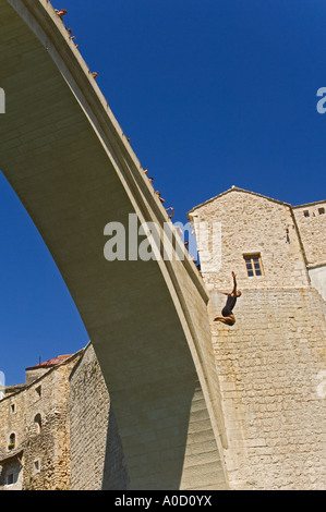 Un professionista subacqueo immersioni dalla nuova vecchio ponte nel fiume Neretva Mostar Bosnia Erzegovina mentre aspetto turistico Foto Stock