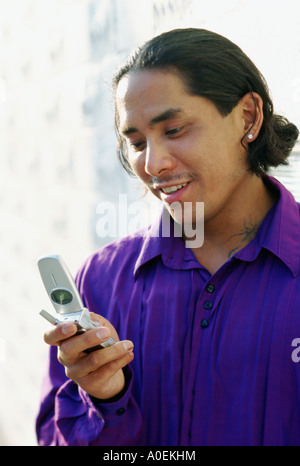 Ritratto di felice giovane utilizzando il telefono cellulare Foto Stock