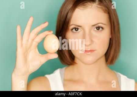 Donna che mantiene l'uovo Foto Stock