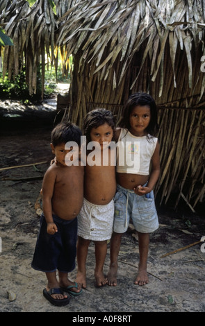 Tre bambini tribali in una foresta pluviale amazzonica Ariau villaggio vicino a Manaus Brasile Foto Stock