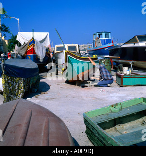 Fisherman pittura la sua barca Msida Creek Malta Foto Stock