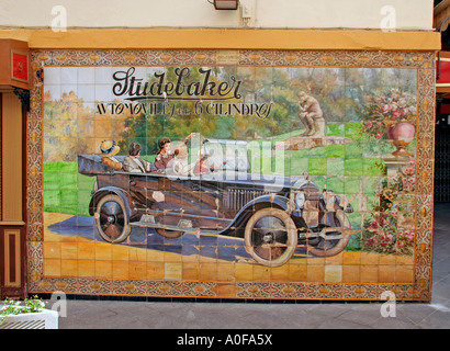 Una foto in piastrelle di ceramica di un vecchio American Studebaker autovettura in Velaquez Tetuan Street Siviglia Andalusia Spagna Foto Stock