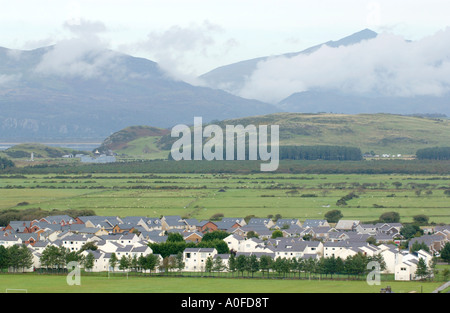 Vista sul moderno quartiere residenziale e Misty Mountains al di là in lingua gallese parlando città di Harlech Gwynedd North Wales UK Foto Stock