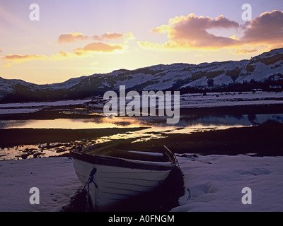 GLENELG Highlands scozzesi UK Febbraio il sorgere del sole riflessa nella Glenmore estuario del fiume con una bianca barca a remi nella neve Foto Stock