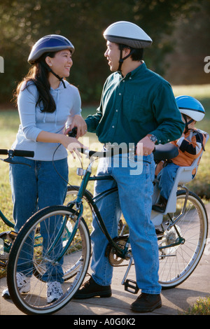 I genitori con il loro figlio che indossa caschi ciclismo Foto Stock