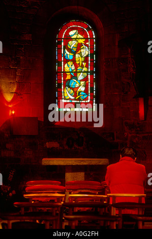 Uomo seduto in chiesa a pregare, interni di Vetrate di chiesa a Parigi,Francia Foto Stock