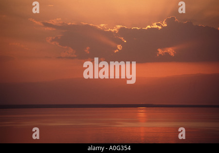 Il Mar Morto con il sole che tramonta dietro le montagne di West Bank Foto Stock