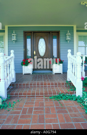 Sportello anteriore della casa tradizionale in mattoni con il marciapiede qualsiasi ivy e passaggi a portico con il rosso dei gerani, Missouri USA America Foto Stock