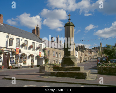 Mercato di arenaria croce e borgo medievale di warkworth con il castello di warkworth oltre, Northumberland, Inghilterra, Regno Unito. Foto Stock