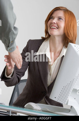 Imprenditrice stringono le mani con un collega Foto Stock