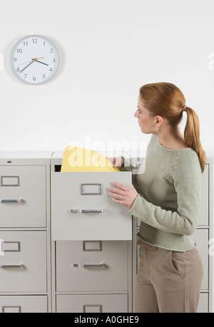 Donna con file guardando orologio Foto Stock