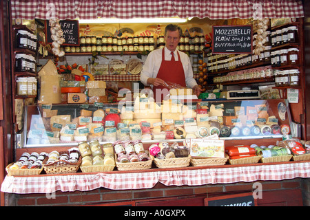 Uomo di formaggio di avvolgimento su una fase di stallo nel mercato di York Foto Stock