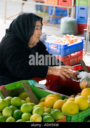 Una donna locale nel tradizionale nero, al mercato nel centro della città vecchia di Paphos, Cipro Foto Stock