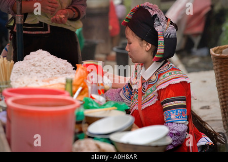 Piuttosto giovane minoranza Yi donna in abiti etnici vendita di tagliatelle, Yuanyang ,Yunnan, Cina Foto Stock