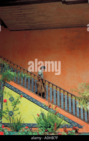 Uomo di discesa delle scale di hotel che conduce al cortile interno di San Cristobal de las Casas, Chiapas Foto Stock
