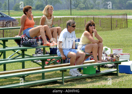Ventole a una femmina adolescente Major League Softball game ubicazione in gabbie. Foto Stock