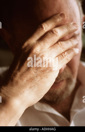 Primo piano dell'anziano con la mano alla testa. Ritratto di maschio profondo nel pensiero. Grave, stanco, depresso, pensionato di vecchiaia preoccupato. Foto Stock