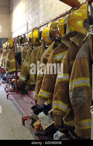 Giallo fighters caschi e vestiti appesi sulla stazione muro di casa. Foto Stock