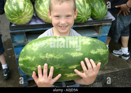 Cleveland Ohio,Westside Market,market,cocomero,ragazzo sorridente,ragazzi,bambini,in mano,produrre,frutta,verdura,verdura,cibo,OH0612040047 Foto Stock