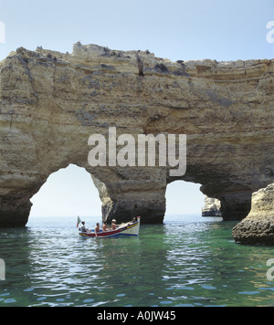 Il Portogallo Algarve, i turisti ad esplorare le grotte e scogliere, vicino a Armacao de Pera escursione in barca da pesca Foto Stock