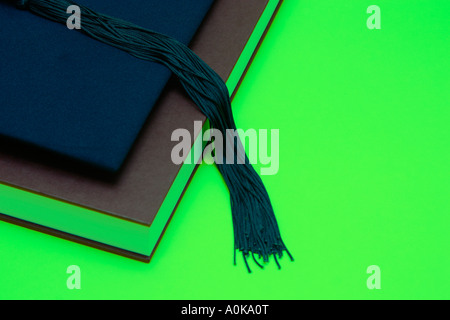 Tappo di graduazione sulla parte superiore di un libro di spessore e scorrimento della carta Foto Stock