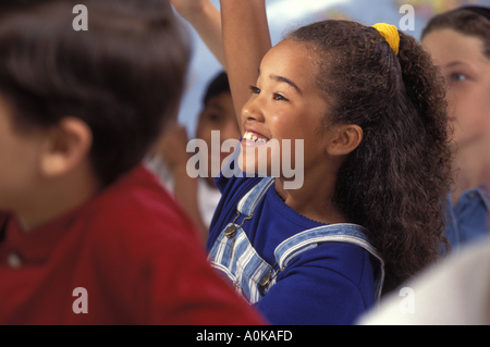 African American studentessa alzando la mano in middle school classroom Foto Stock