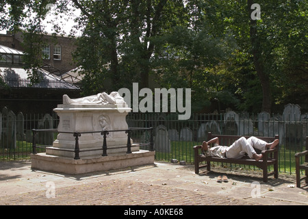 Uomo dorme sul banco in campi Bunhill sepoltura a Londra GB UK. Foto Stock