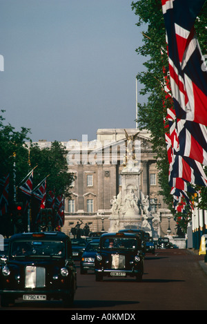 Londra taxi auto giù il Mall in passato di Londra Buckingham Palace Foto Stock