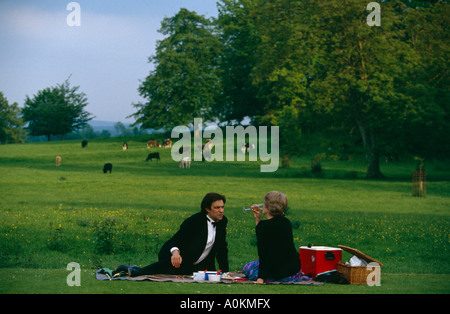 A couple picnic in the grounds during the interval at the famous Glyndebourne Opera in Sussex England Foto Stock