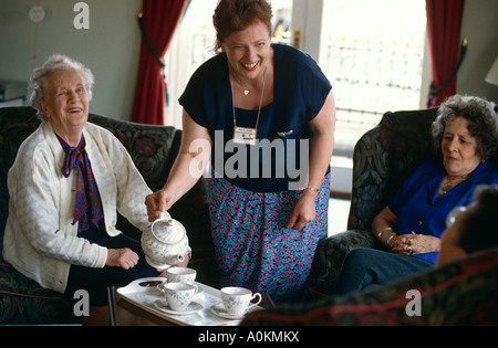 Un assistente di cura caregiver versa il tè per i residenti in un vecchio persone persone home in Braintree Essex Londra Inghilterra GB UK Foto Stock