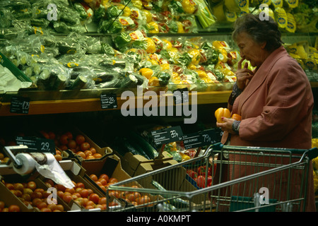 Una donna che guarda i pomodori della frutta e della verdura sezione di un supermercato Asda a Dewsbury,Yorkshire, Inghilterra Foto Stock