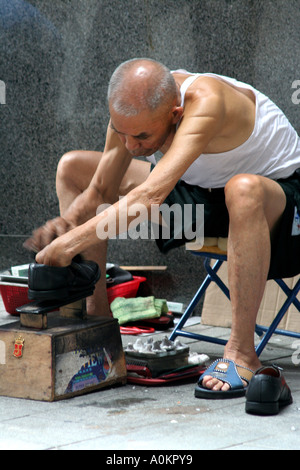 Uomo anziano shining scarpe nel distretto centrale di Hong Kong SAR, Foto Stock