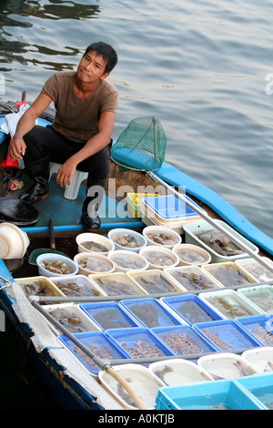 Uomo di vendita del pesce dalla sua barca, Sai Kung Town, Sai Kung Penisola, Hong Kong Foto Stock