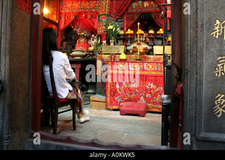 Donna seduta all'interno di Hung Shing Tempio a Wan Chai, Hong Kong Foto Stock