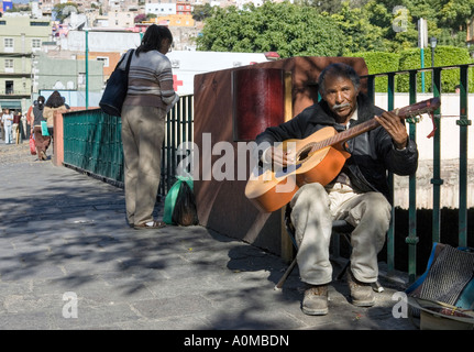 Musicista che gioca per la alms in una strada del centro città di Guanajuato un sito Patrimonio Mondiale dell'UNESCO Foto Stock