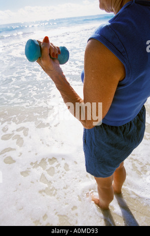 Hawaii Oahu Kailua Beach donna senior di allenamento con i pesi a mano Foto Stock