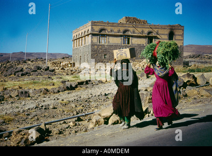 Donne che trasportano prodotti e colture sulle loro teste Sanaa Yemen Foto Stock