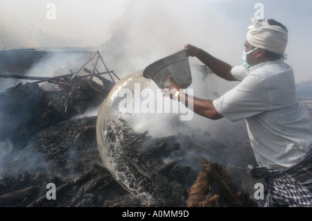 L'uomo versando olio sulla pira funeraria dopo lo tsunami terremoto Nagapattinum Velankanni Tamil Nadu India Foto Stock