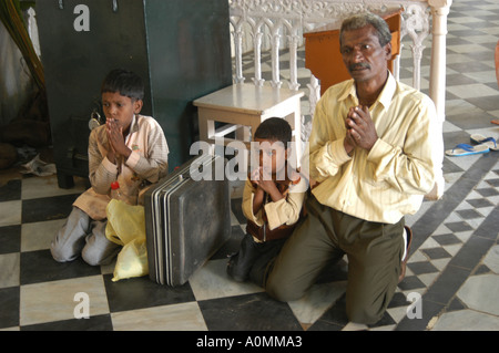Uomo con due bambini pregano in chiesa per moglie mancanti dopo lo tsunami terremoto Nagapattinum Velankanni Tamil Nadu India Foto Stock