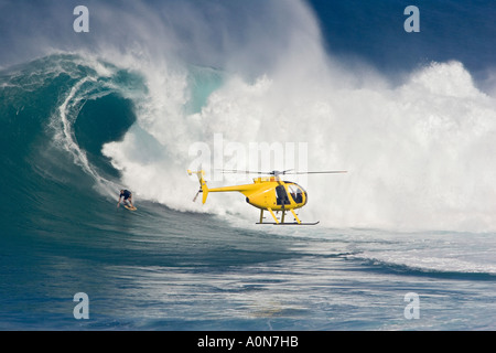 Un elicottero riprese in traino, surfista Laird Hamilton a Peahi, (ganasce) off Maui, Hawaii. Foto Stock