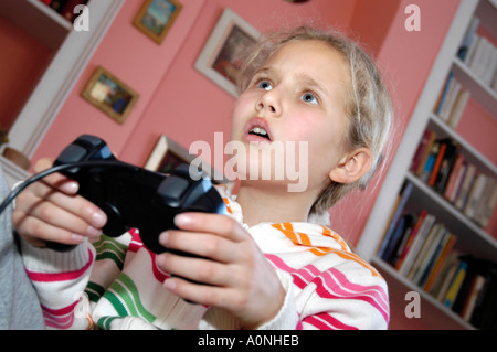 Ragazza giovane la riproduzione di giochi per computer su Sony Playstation console, England, Regno Unito Foto Stock