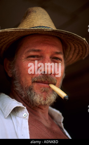 L'Amazzonia, Brasile. Vecchio colono di aspetto europeo indossando un cappello di paglia e fumare una pelle di mais sigaretta; Minas Gerais Stato. Foto Stock