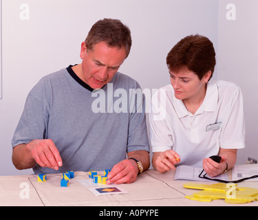 Ospedale. Terapia Occupazionale. Test di destrezza. Fisioterapista femmina con paziente di sesso maschile. Foto Stock