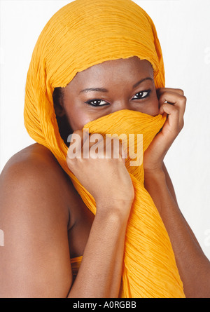 Ritratto di una timida ragazza nera con un velo di colore giallo Foto Stock