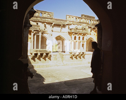 Vista della caratteristica elaborati scolpiti nella pietra tempio indù parete da sotto un arco Hampi Karnataka India Asia del Sud Foto Stock