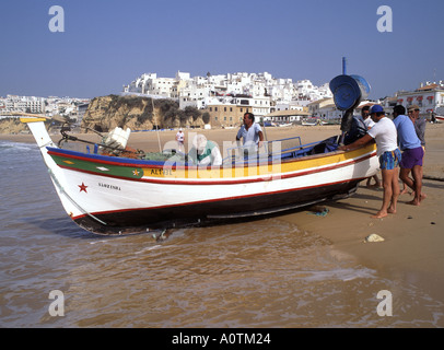 Albufeira gruppo di pescatori a bordo acque si preparano a. lancia la barca da pesca in mare durante la popolare vacanza cielo blu spiaggia Algarve Portogallo Europa Foto Stock