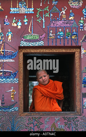 Monaco novizio nella finestra del mosaico decorato tempio di Wat Xieng Thong Luang Prabang s più famoso monastero Laos sito UNESCO Foto Stock